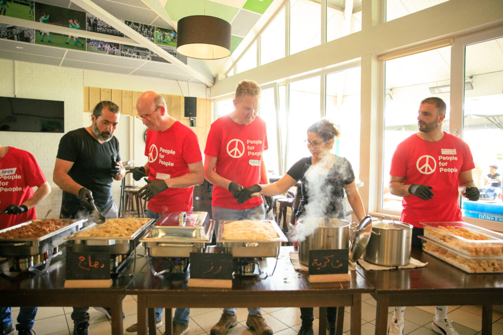 Zaher Shalhoub serving a delicious meal at one of People for People's Rolling Aid Events for unaccompanied minors