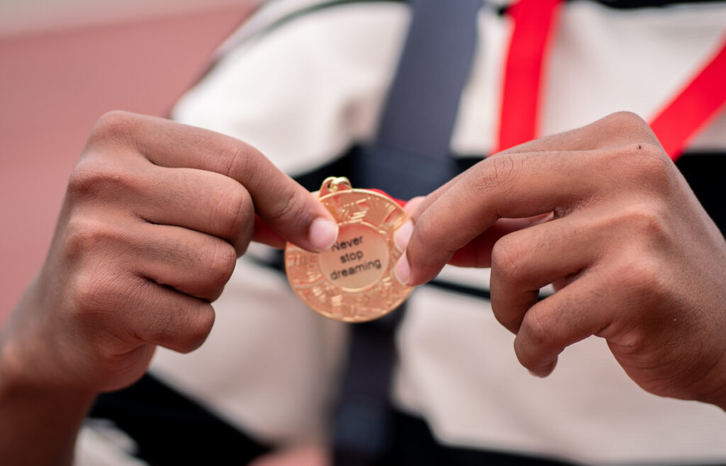 A close up of a medal which says "Never stop dreaming"