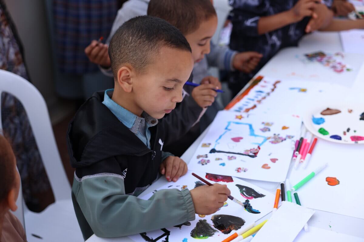 A boy paints at a workshop organised by People for People in al Haouz, Morocco