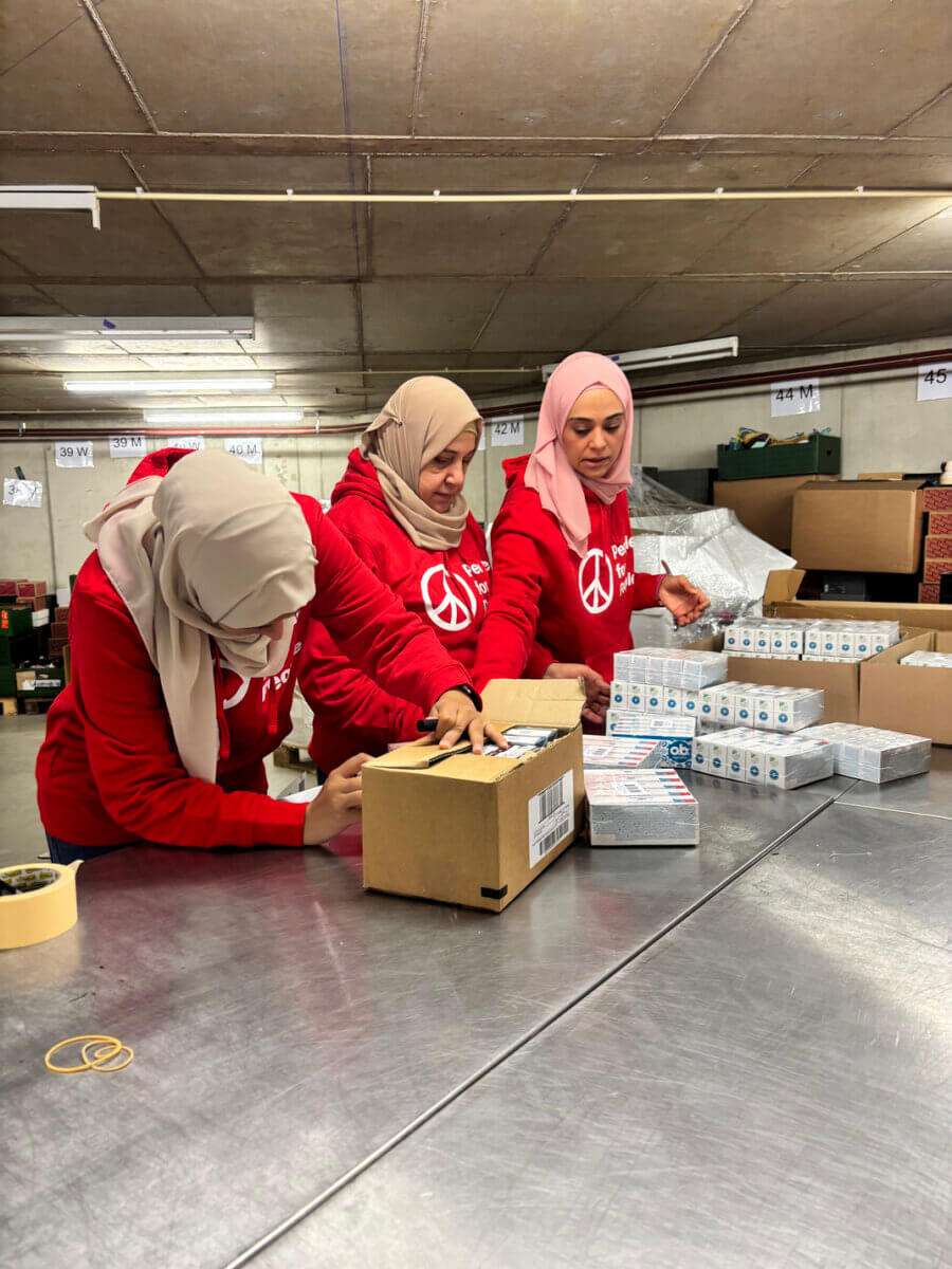 Volunteers pack supplies at People for People's warehouse